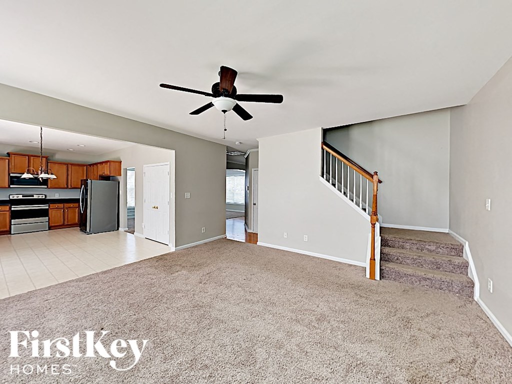 A spacious living room with a staircase leading to the upper floor.