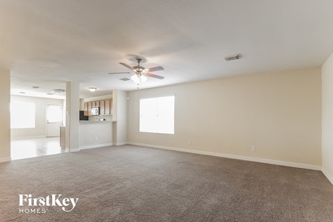 a living room with carpet and a ceiling fan