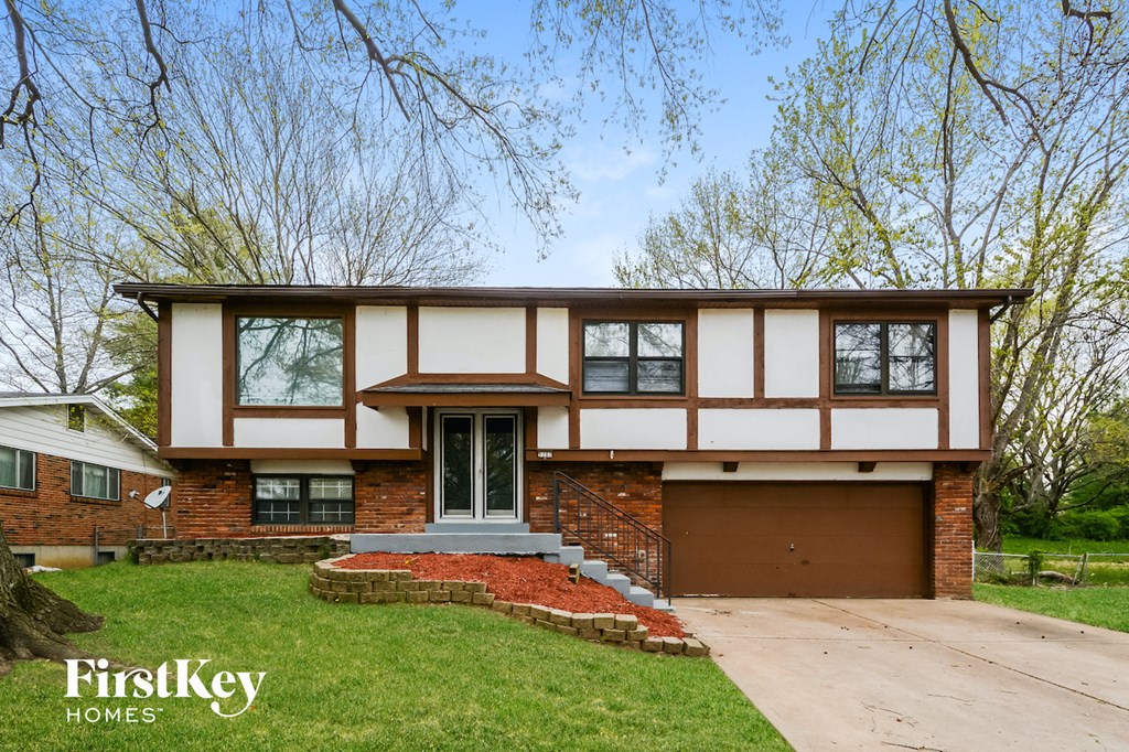 A house with a brick wall and a garage door.