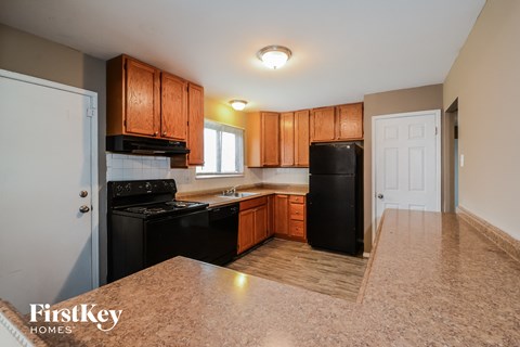A kitchen with wooden cabinets and black appliances.