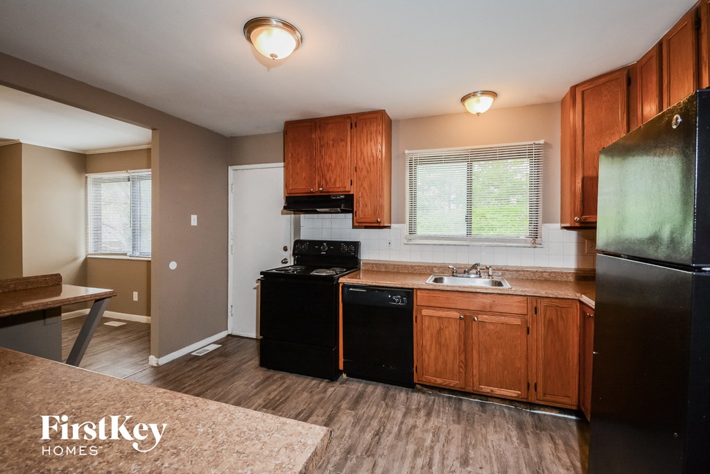 A kitchen with wooden cabinets and black appliances.