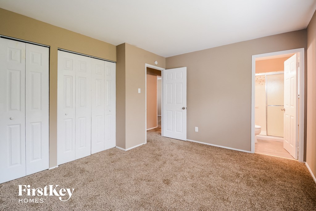 A room with a carpeted floor and a white door.