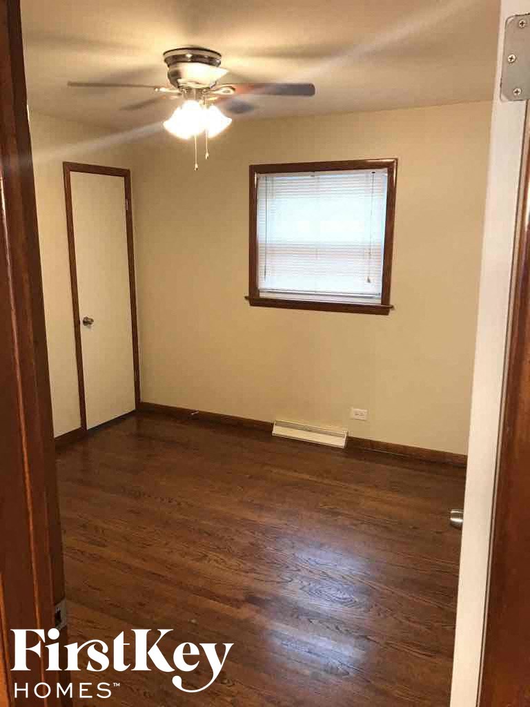 an empty room with a ceiling fan and a window