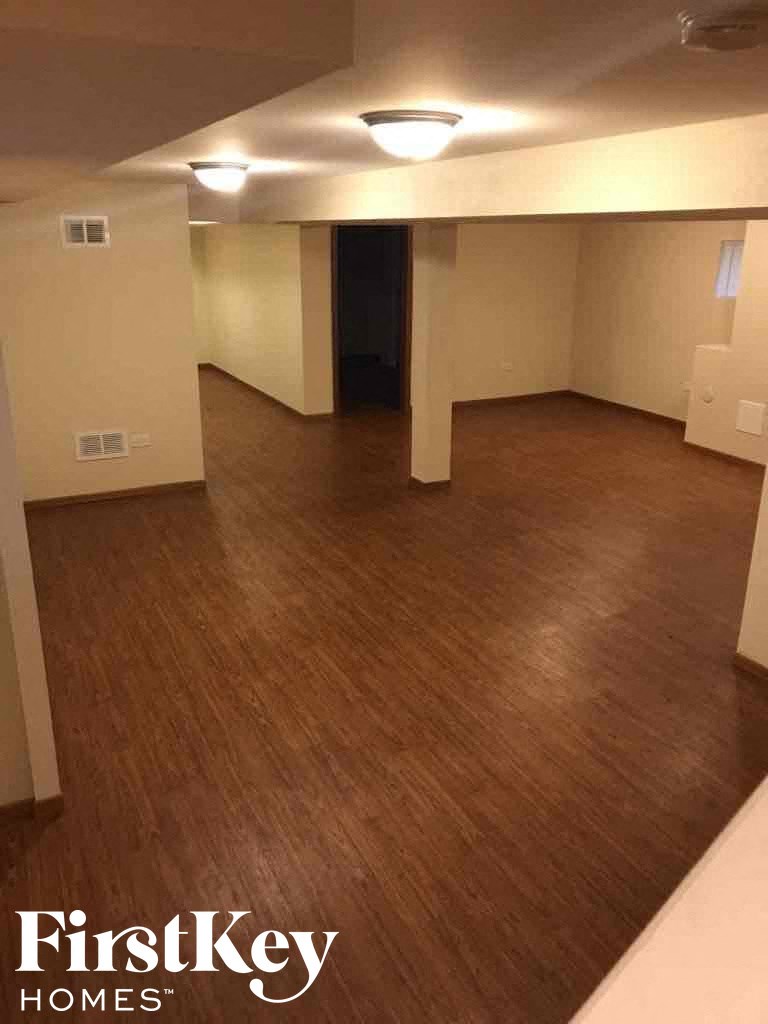 an empty living room with a wooden floor and white walls
