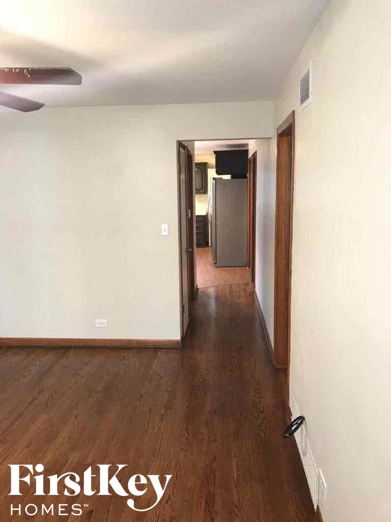 an empty living room with wood flooring and white walls