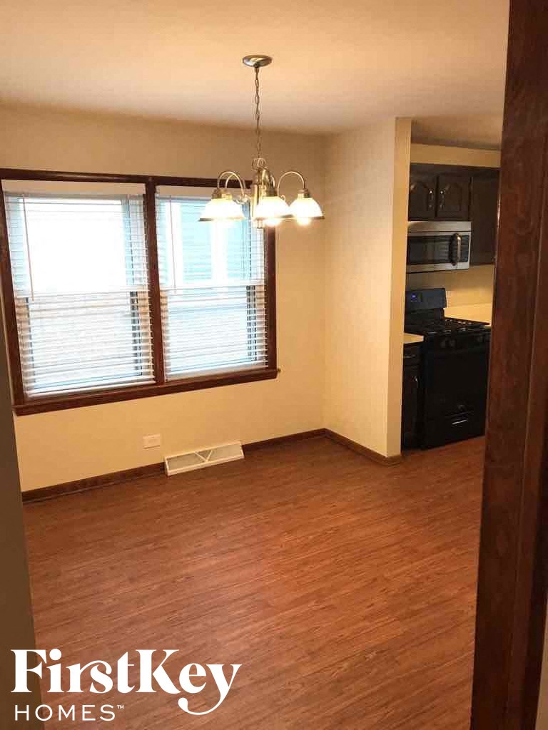 an empty living room with a wood floor and a window