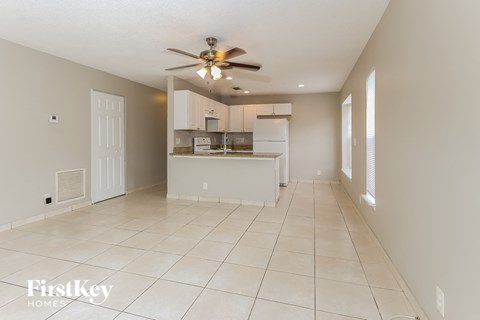 an empty kitchen and living room with a ceiling fan