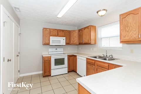 A kitchen with wooden cabinets and white appliances.