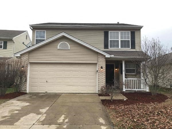 A house with a grey roof and a white garage door.