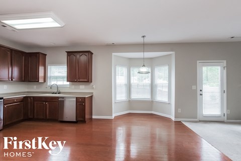 A kitchen with brown cabinets and a FirstKey Homes logo.