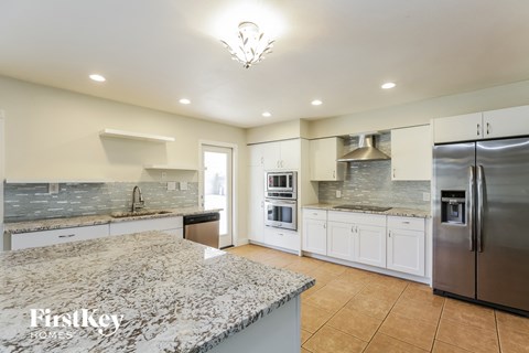 a large kitchen with marble counter tops and stainless steel appliances