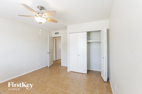 a bedroom with a ceiling fan and a closet