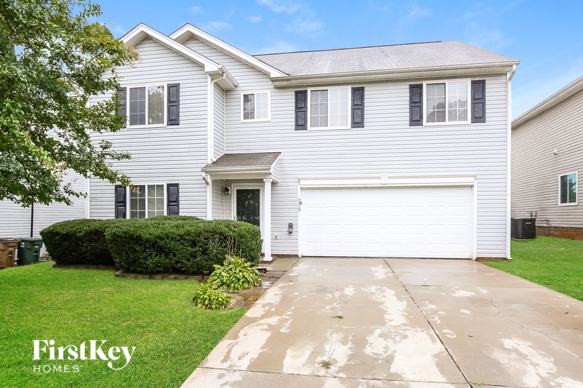 A two-story house with a garage and a driveway.