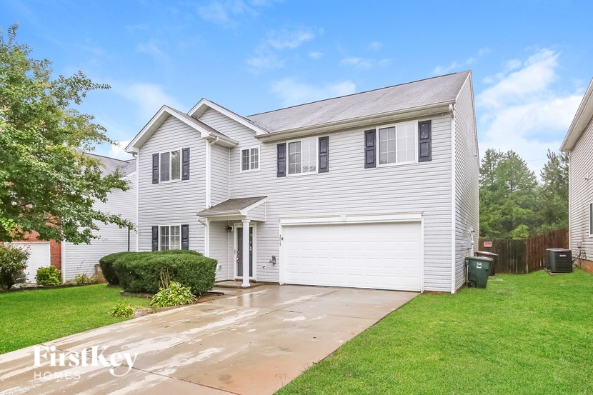 A two-story house with a garage and a driveway.