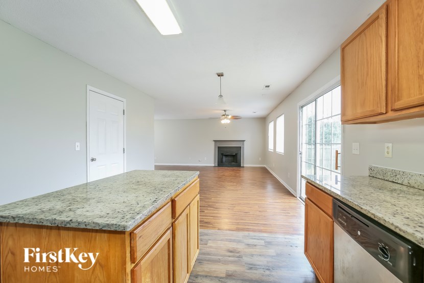 A kitchen with wooden cabinets and a granite countertop.
