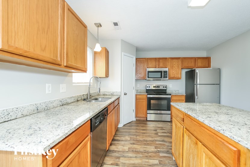 A kitchen with wooden cabinets and a granite countertop.