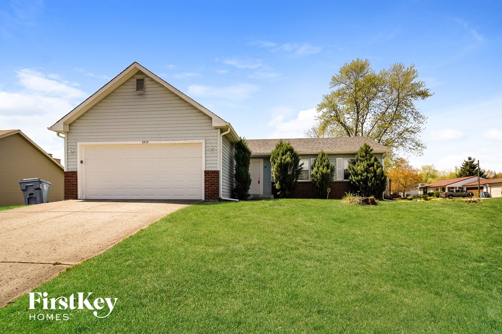 a home with a lawn and a white garage door