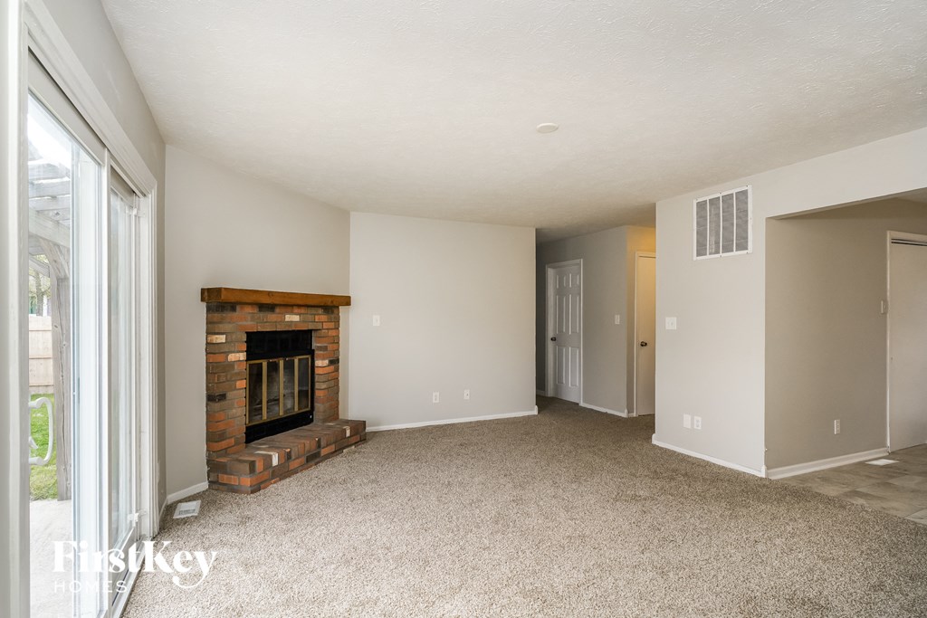 a living room with a fireplace and a door to a hallway