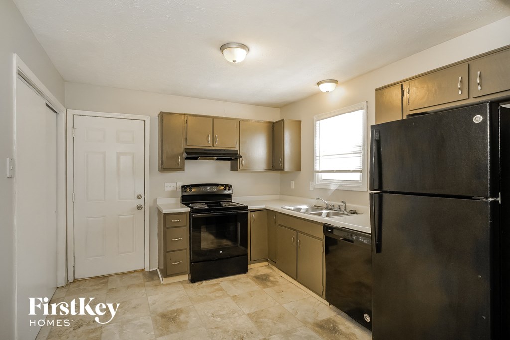 a kitchen with black appliances and a black refrigerator