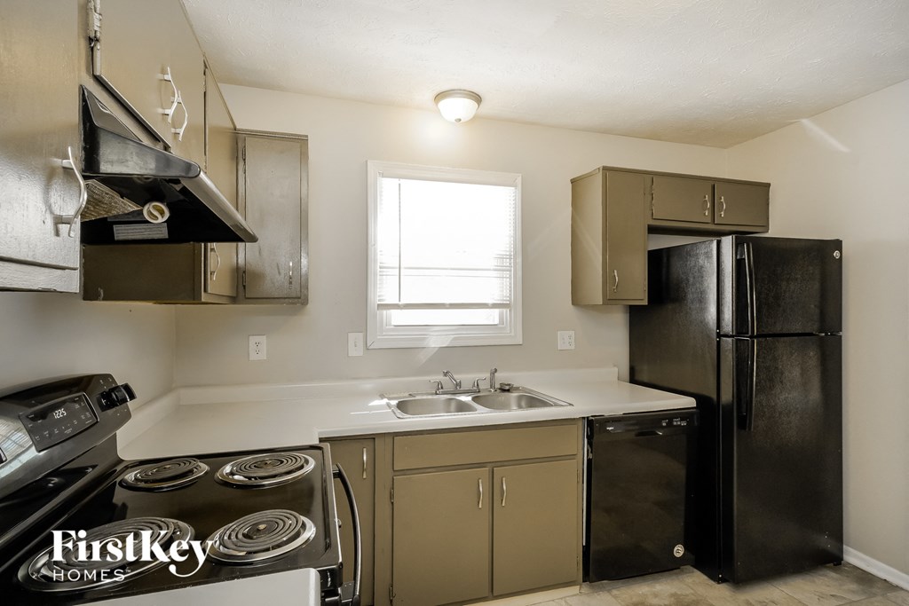 a kitchen with a stove and a refrigerator and a sink