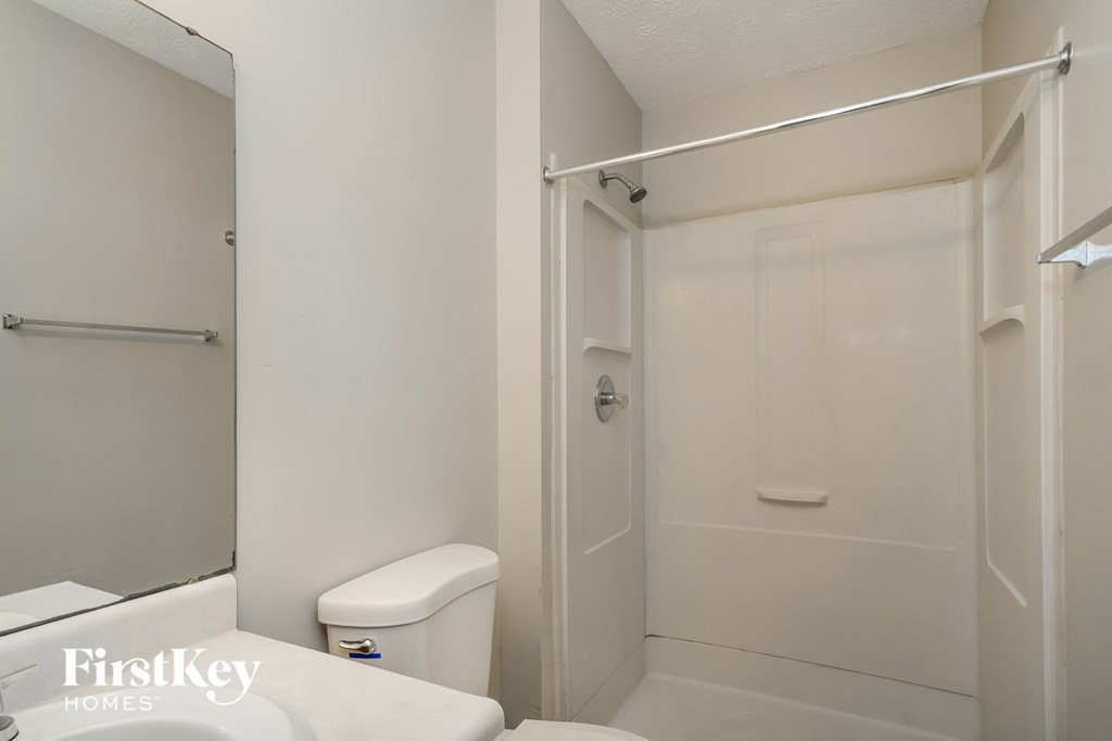 a bathroom with a shower and a toilet and a sink