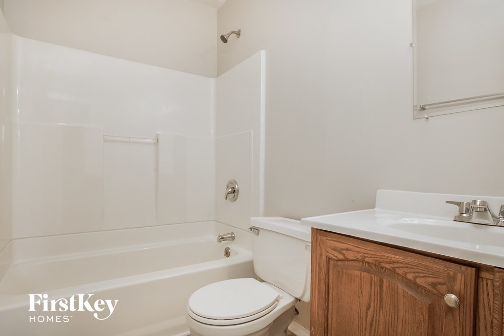 a bathroom with a toilet and a sink and a bath tub