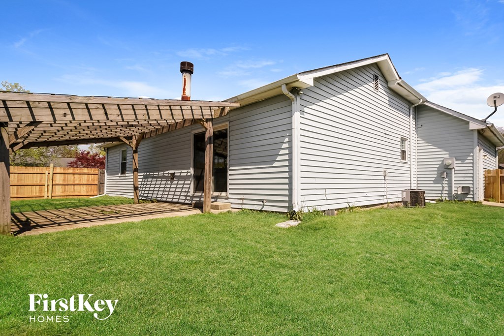 the outside of a house with a covered porch and a lawn