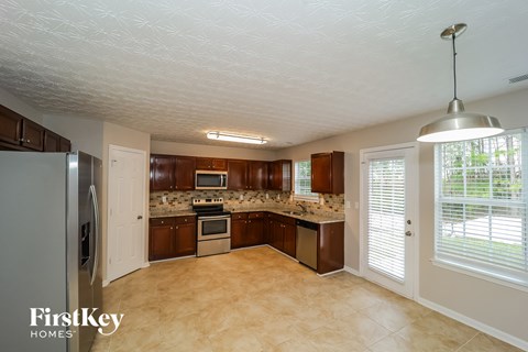 a kitchen with wood cabinets and stainless steel appliances and a large window