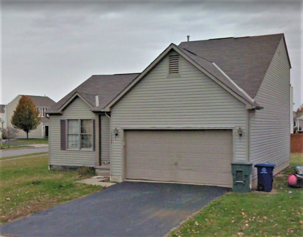 the front of a white house with a garage