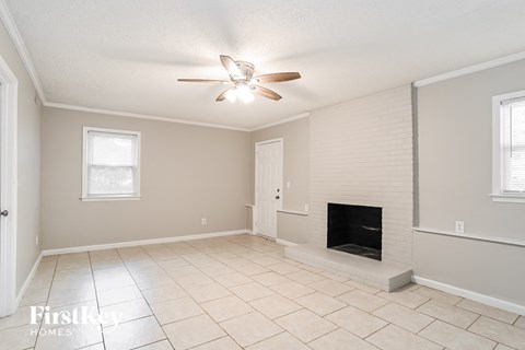 a living room with a fireplace and a ceiling fan