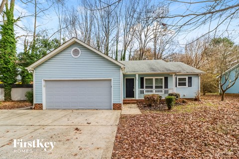 A blue house with a white garage door is for sale.
