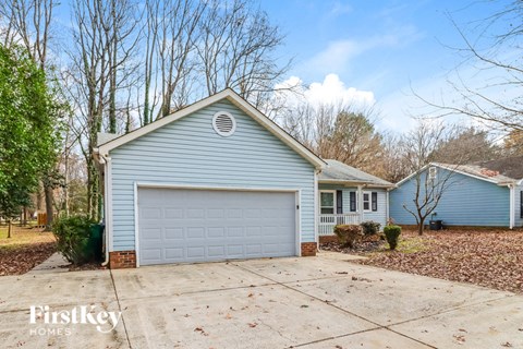 A blue house with a white garage door is for sale.