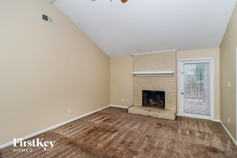 A room with a fireplace and a window with blinds.