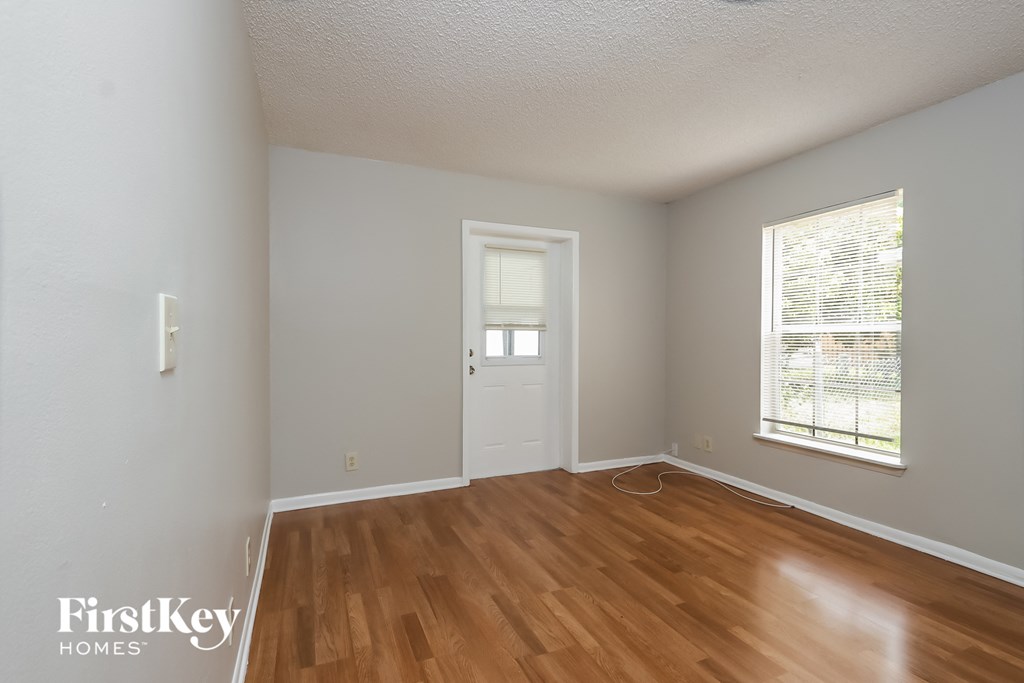 the living room of a house with wood floors and a white door