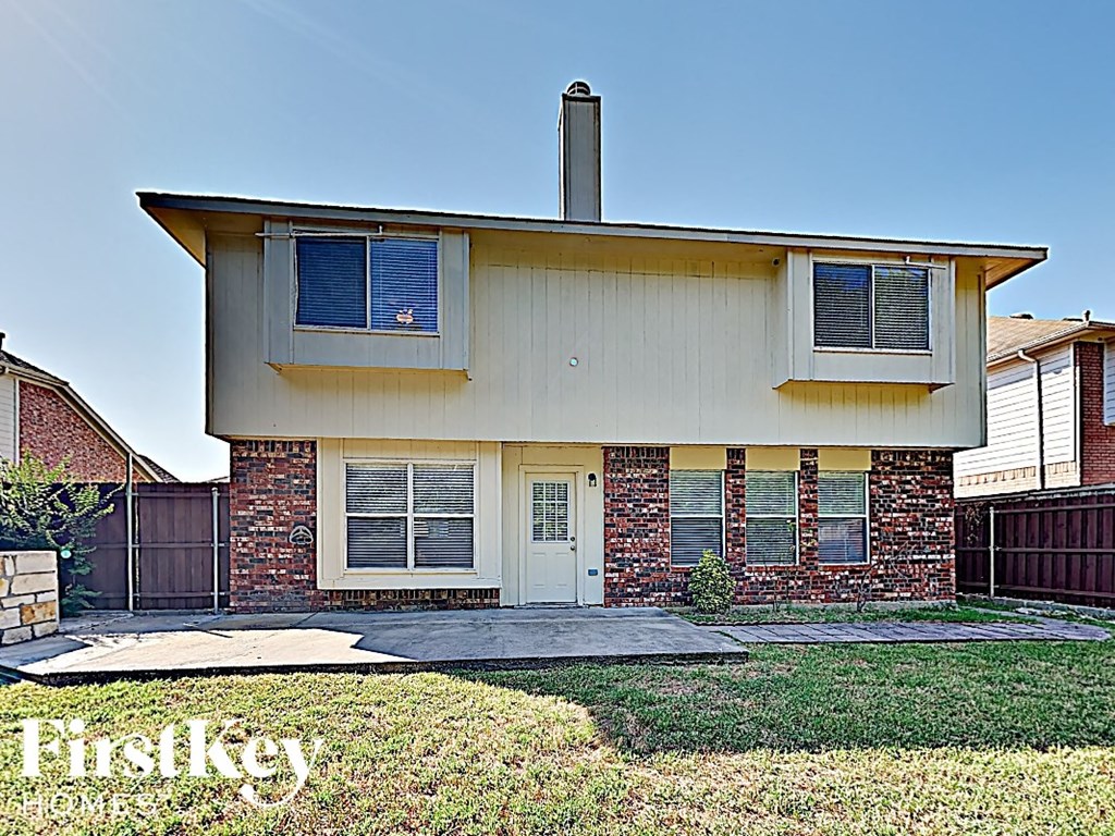 a small brick house with a yard in front of it