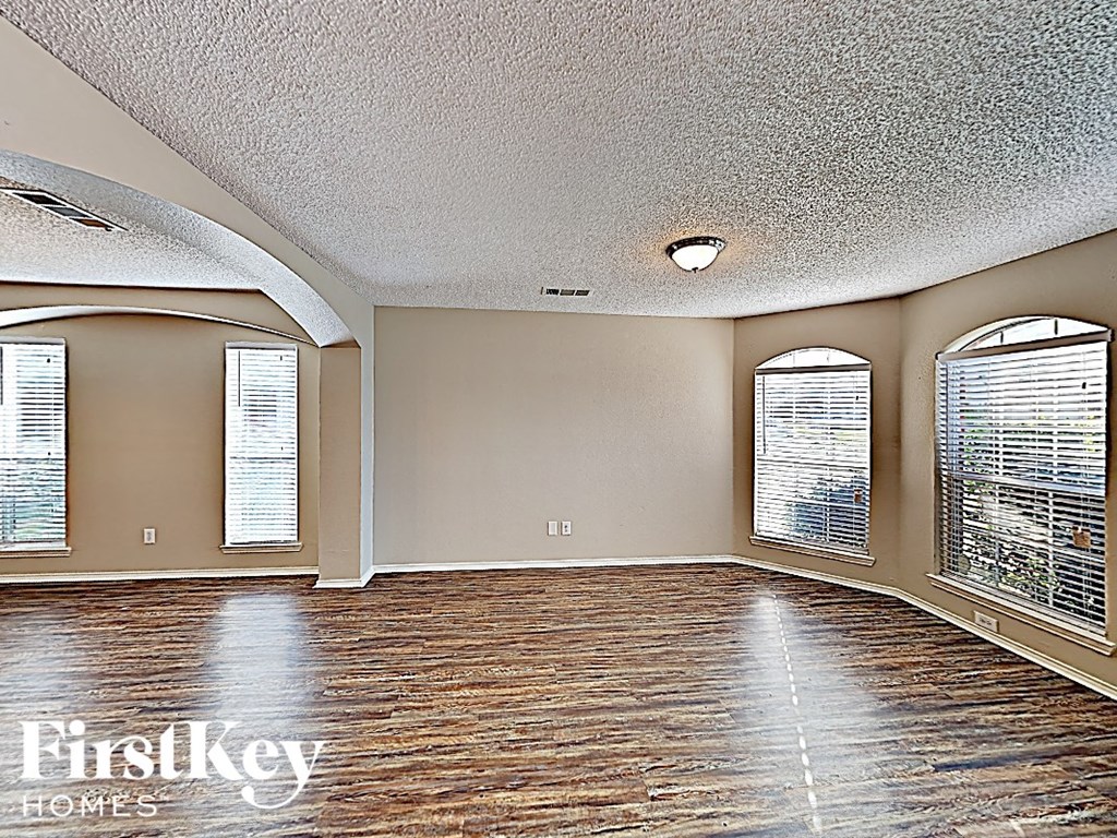 an empty living room with large windows and a mirrored ceiling