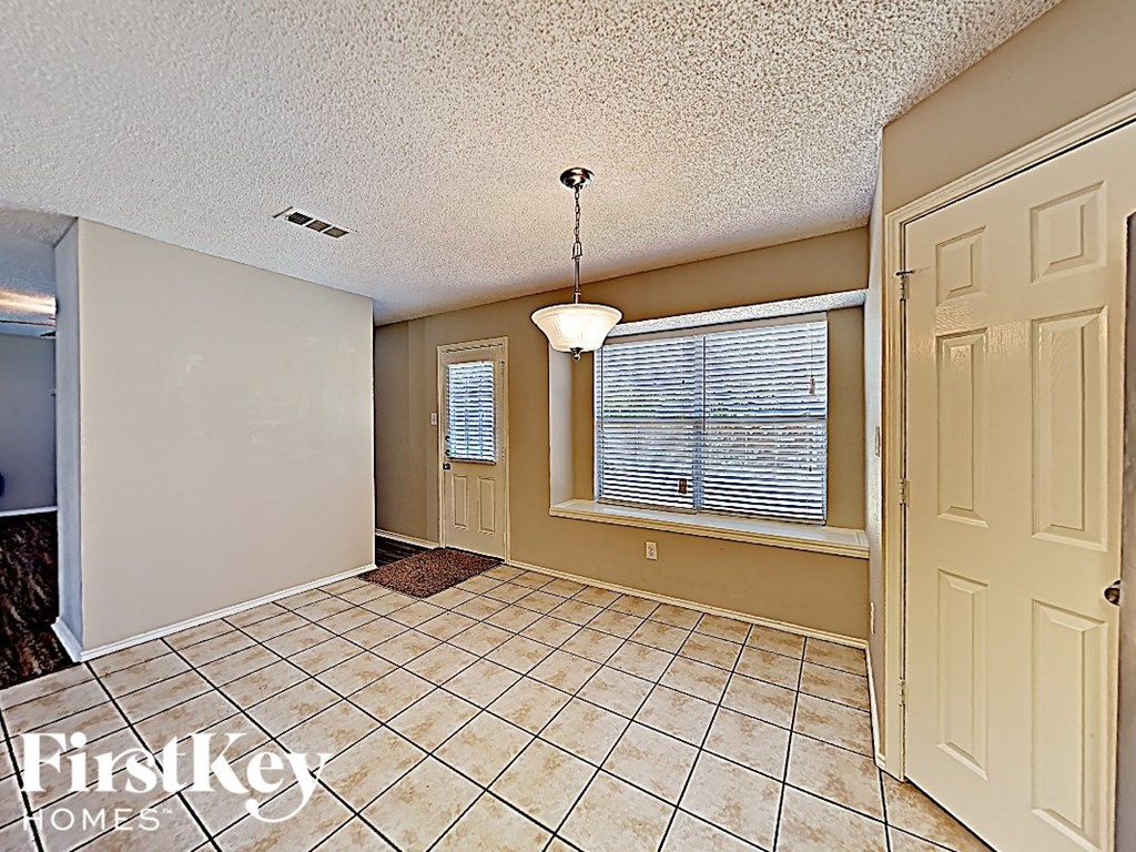 an empty living room with a window and a white door