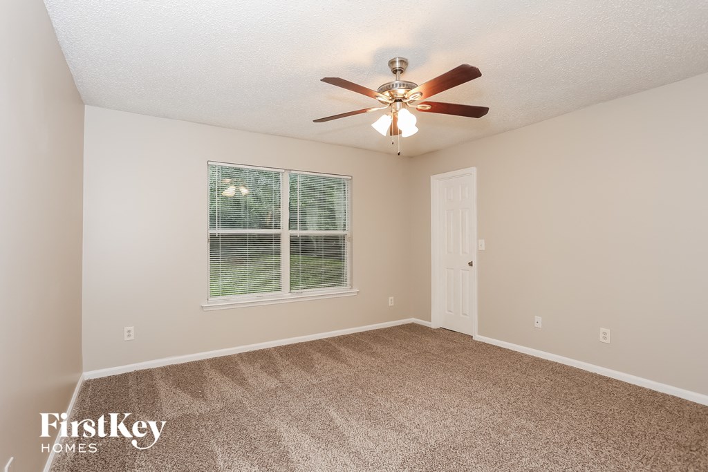a bedroom with a ceiling fan and a window
