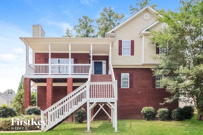 A house with a red brick chimney and a white porch.