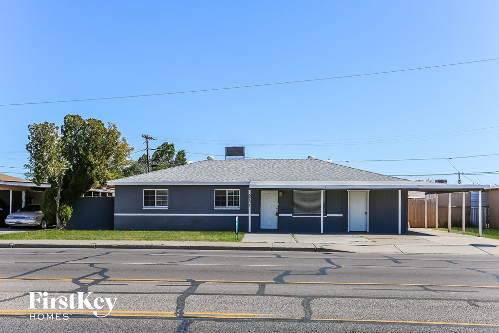 a blue house with a gray roof on a street
