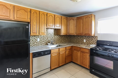 a kitchen with wooden cabinets and black appliances and a sink