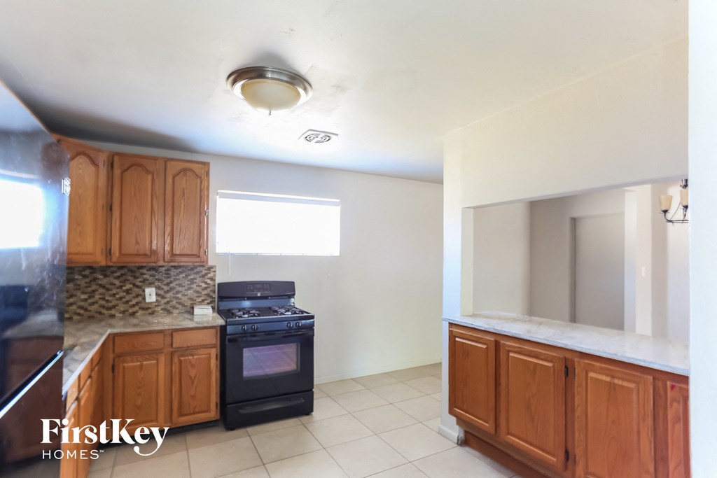 a kitchen with wooden cabinets and a stove and a sink
