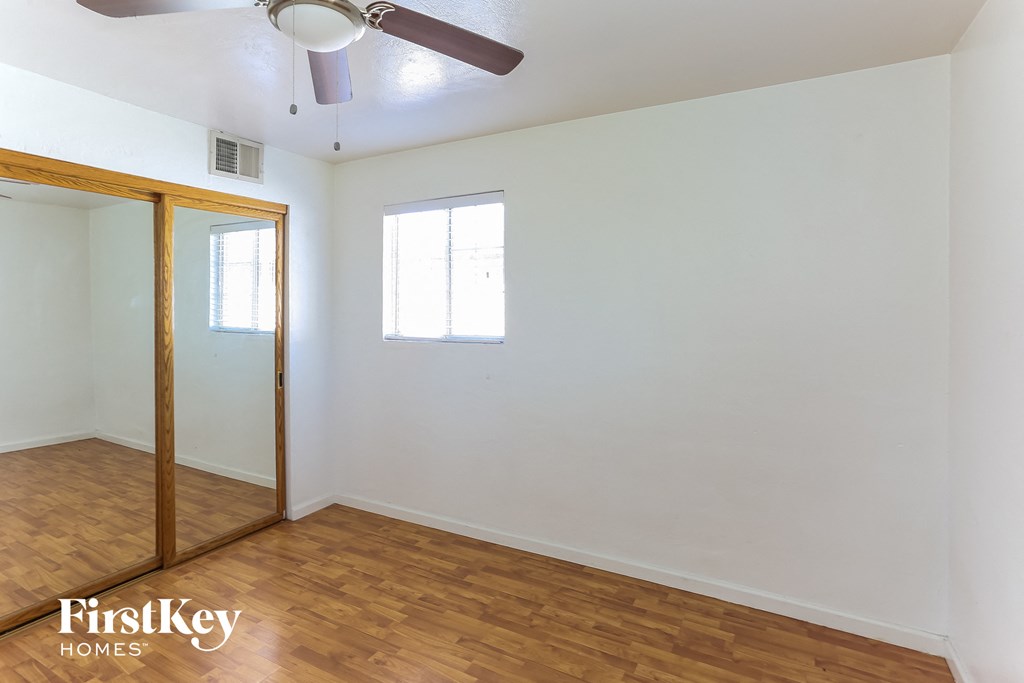 a room with white walls and a wooden floor and a closet