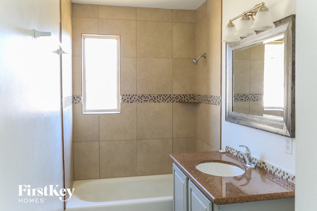 a bathroom with a sink and a tub and a mirror