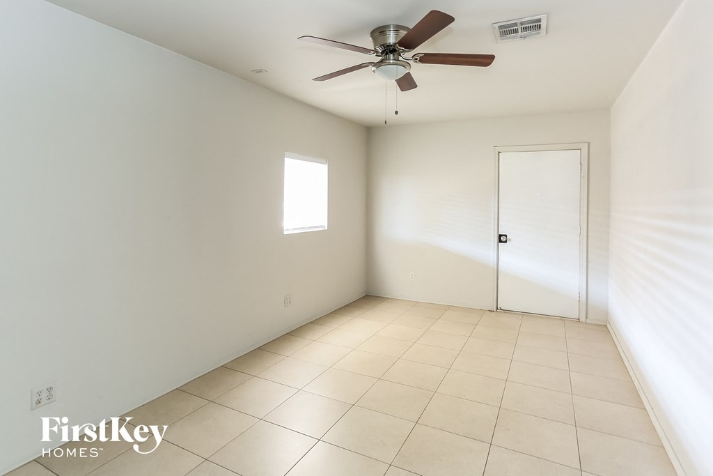 an empty room with a ceiling fan and a white door