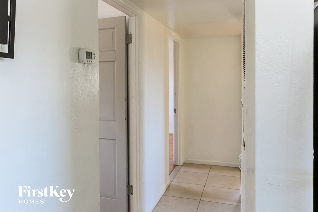 a hallway with a door to a closet and a white door