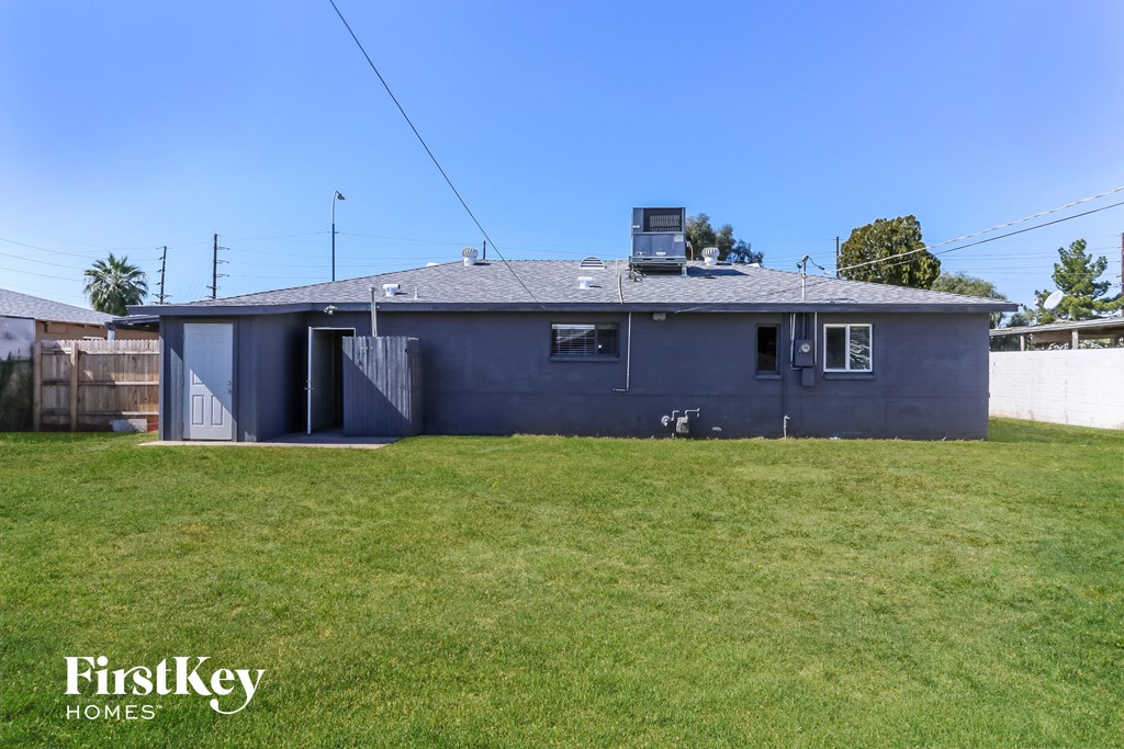 a blue house with a grass yard and a white fence