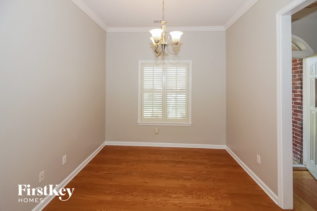 A room with wooden floors and a chandelier.