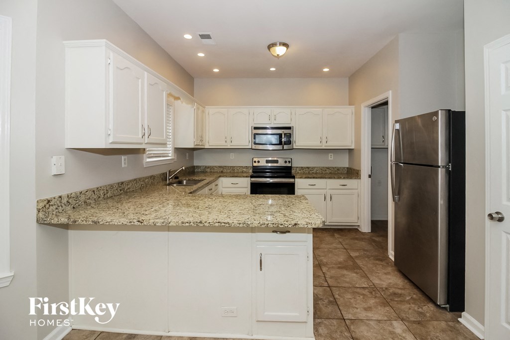 A kitchen with granite countertops and stainless steel appliances.