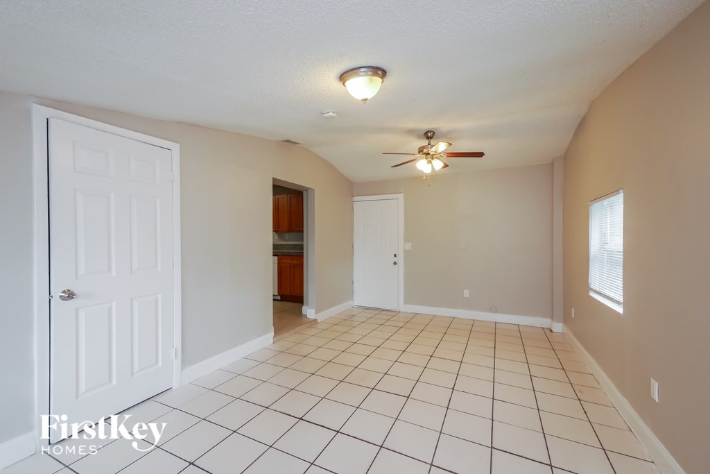 A room with a ceiling fan and tile flooring.